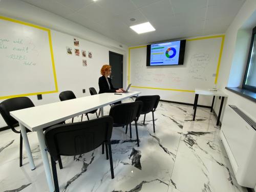 a woman is sitting at a table in a classroom at RUBO Hotel in Shumen