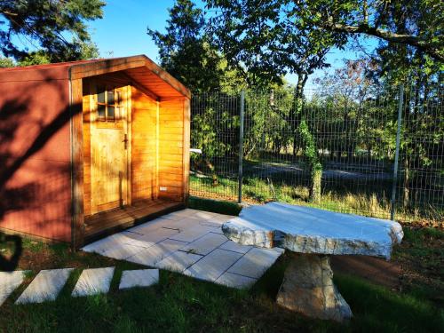 ein Holzhaus mit einer Bank und einem Zaun in der Unterkunft Krasen Kras 104 resort in Komen