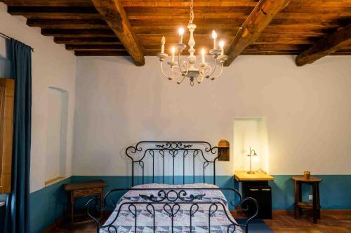 a bedroom with a bed and a chandelier at Agriturismo Bio Fattoria di Pietra in Giuncarico