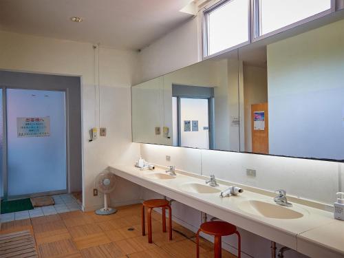 a bathroom with two sinks and a large mirror at Hotel Murasakimura in Yomitan