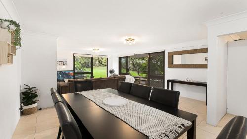 a dining room with a black table and chairs at Terrigal Bay #19 Pool , Short Walk To Beach Accom Holidays in Terrigal