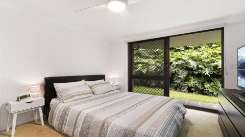 a white bedroom with a bed and a window at Terrigal Bay #19 Pool , Short Walk To Beach Accom Holidays in Terrigal