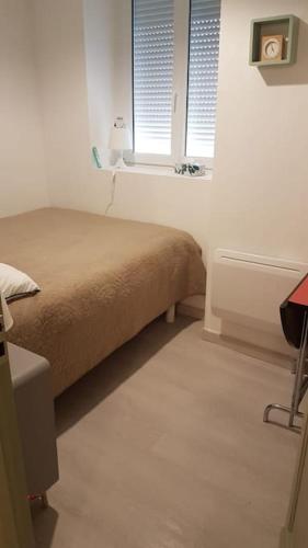 une chambre avec un lit et deux fenêtres dans l'établissement Appartement Cosy à 300m de la Mer / Cosy flat at 300m from the sea, à Merlimont