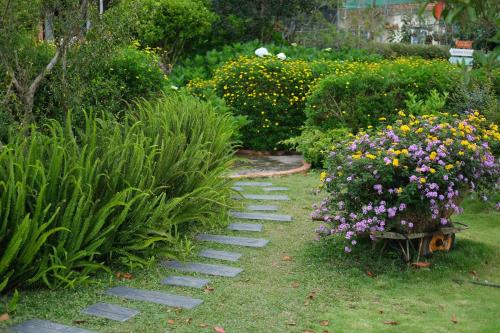 a garden with a path with flowers and plants at La Em Boutique Villa in Da Lat