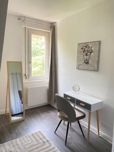 Cette chambre dispose d'un bureau, d'une chaise et d'une fenêtre. dans l'établissement Appartement Cosy à Colmar, à Colmar