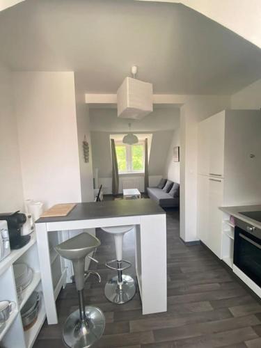 une cuisine avec un comptoir et des tabourets dans une pièce dans l'établissement Appartement Cosy à Colmar, à Colmar