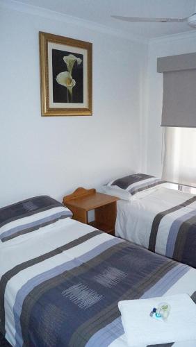 a hotel room with two beds and a picture on the wall at Maude St Apartments in Shepparton