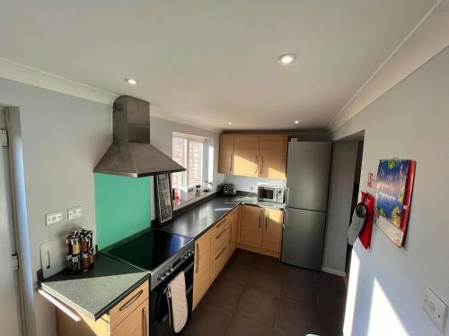 a kitchen with a stove and a refrigerator at Modern 3 bed house 2 parking spaces contractors welcome in Stevenage