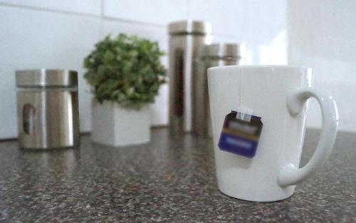 a white coffee cup with a charger on top of a counter at Maude St Apartments in Shepparton