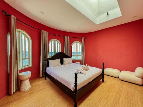 a bedroom with red walls and a bed in it at Renjana Beach House in Bira