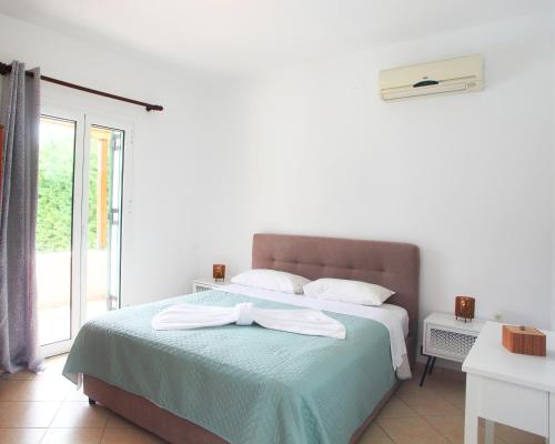 a bedroom with a bed with a bow on it at Echinades Resort in Vasiliki