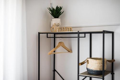 a black shelf with a basket and a plant on it at The Springfield Corner Apartments by Konnect in Ipsos