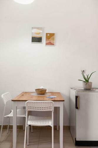 a dining room table with two chairs and a refrigerator at The Springfield Corner Apartments by Konnect in Ipsos