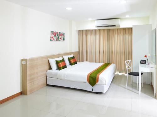 a bedroom with a bed and a desk in it at The Plimplace Hotel in Bang Su
