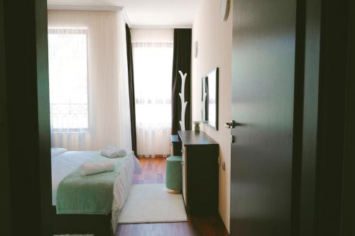 ein Schlafzimmer mit Bett, Schreibtisch und Fenster in der Unterkunft Golden Sands - Two Bedroom apartment on the beach in Goldstrand