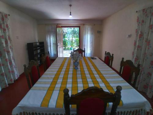 una mesa con un mantel de rayas amarilla y azul en Jayathmaguest en Peradeniya