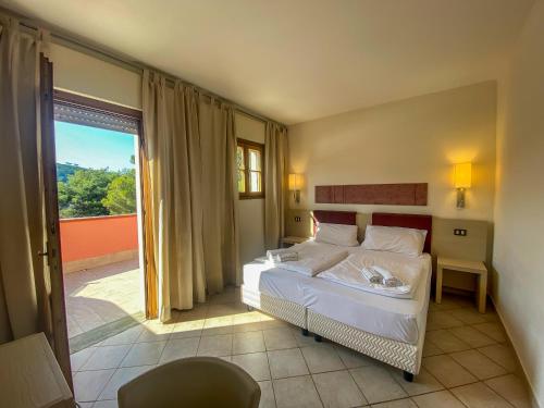 1 dormitorio con 2 camas y ventana grande en La Mandola eco Hostel, en Capraia