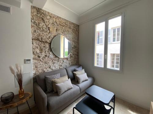 salon z kanapą i lustrem w obiekcie Au cœur du viel Antibes - Cosy appartement w mieście Antibes