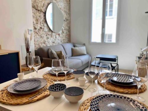 une table avec des assiettes et des verres à vin dessus dans l'établissement Au cœur du viel Antibes - Cosy appartement, à Antibes