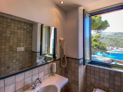 łazienka z umywalką i oknem w obiekcie La Mandola eco Hostel w mieście Capraia