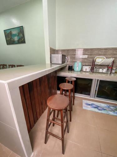a kitchen with two stools and a counter top at Ceiba View Homestay in Dungun