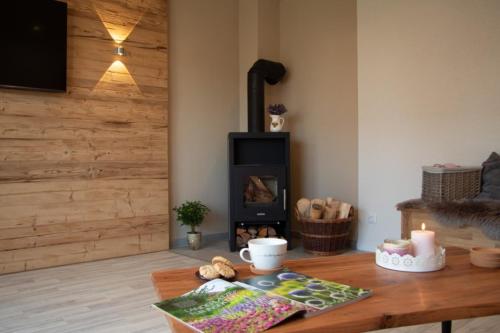 a room with a wooden table with a wood stove at FLAIR Bad Rodach - 5 Sterne Ferienwohnungen in Bad Rodach