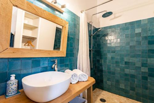 uma casa de banho com um lavatório branco e um espelho. em Au petit bonheur em Bédoin
