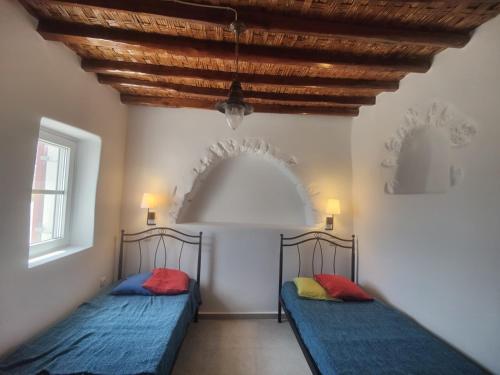 2 łóżka w pokoju z drewnianym sufitem w obiekcie Orania, heaven in Mykonos w mieście Agios Sostis Mykonos