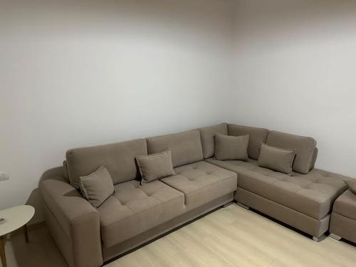 a living room with a couch with pillows on it at Jons Apartment in Gjirokastër