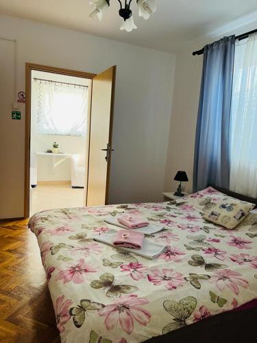 a bedroom with a large bed with pink flowers on it at Rooms Verda in Senj