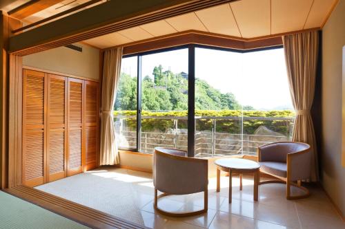 a room with a table and chairs and a large window at Kinzan in Kobe