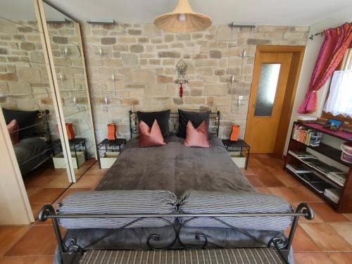 a bedroom with a large bed with red pillows at CASA ALLA CASCATA House by the Waterfall and Garden of Senses in Maggia