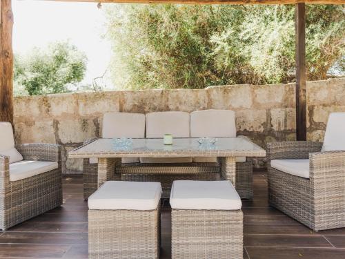 a patio with wicker chairs and a table at Llucamar Villa in Sant Llorenç des Cardassar