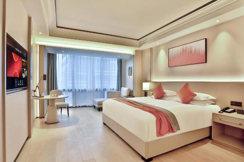 a bedroom with a large bed and a living room at SSAW Boutique Hotel Yingyang in Hangzhou