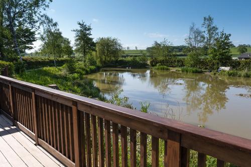 a view of a pond from a wooden deck at Lakeside Lodges in Leicester