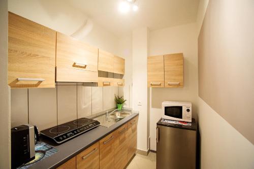 cocina pequeña con fogones y microondas en Sweet apartments with free private parking en Liubliana