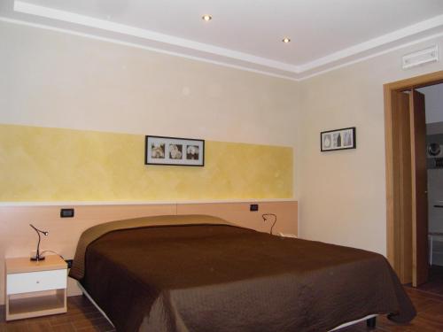 a bedroom with a bed with two pictures on the wall at Ristorante Locanda Milano in Gambolò