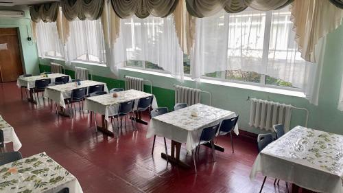 a room with tables and chairs and windows at Sanatoriy Samara 