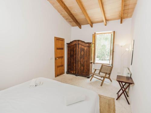 a bedroom with a bed and a chair and a window at Llucamar Villa in Sant Llorenç des Cardassar