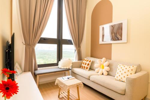 a living room with a couch and a large window at Sunway Grid Loft Suite by Nest Home【Olympic Size Pool】 in Kampong Pendas