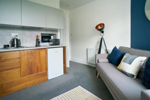a living room with a couch and a kitchen at Meadow Apartment in Dumbarton