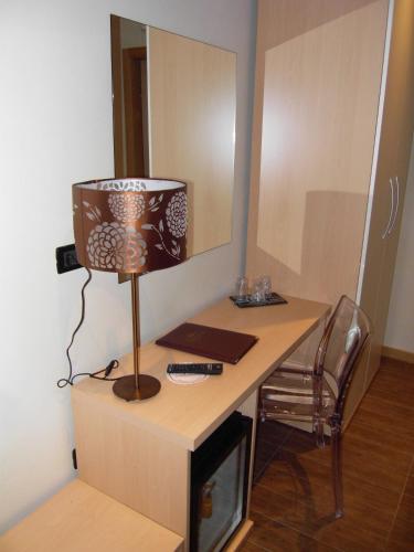 a room with a desk with a lamp and a mirror at Ristorante Locanda Milano in Gambolò