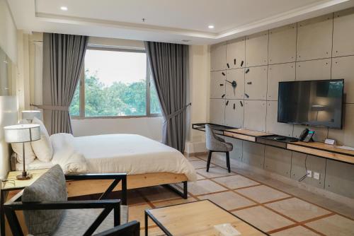 a hotel room with a bed and a tv at Roomy Signature Hotel, Islamabad in Islamabad