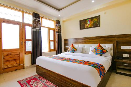 a bedroom with a large bed and a window at FabHotel The Eden in Dharamshala