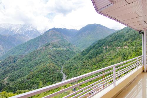 a balcony with a view of a mountain range at FabHotel The Eden in Dharamshala