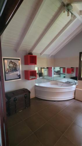 Habitación grande con bañera grande en una habitación con armarios rojos. en Villa Mango en Le Gosier