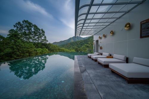 a pool with lounge chairs and a view of a mountain at Wish Garden Huangshan in Yi