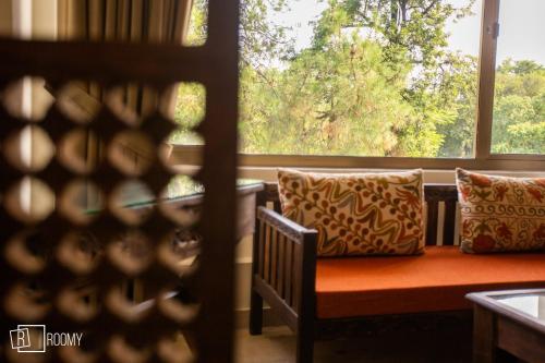 a bench with pillows in front of a window at Roomy Signature Hotel, Islamabad in Islamabad