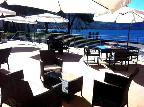 a patio with tables and chairs and umbrellas at A Lago in Marone