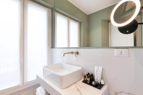a bathroom with a white sink and a mirror at PRESTIGE BOUTIQUE APARTHOTEL - Piazza Duomo View in Milan